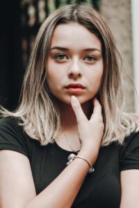 A woman focuses attention to her lips with her fingers