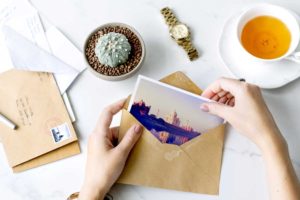 A person packs a personalized postcard in an envelope