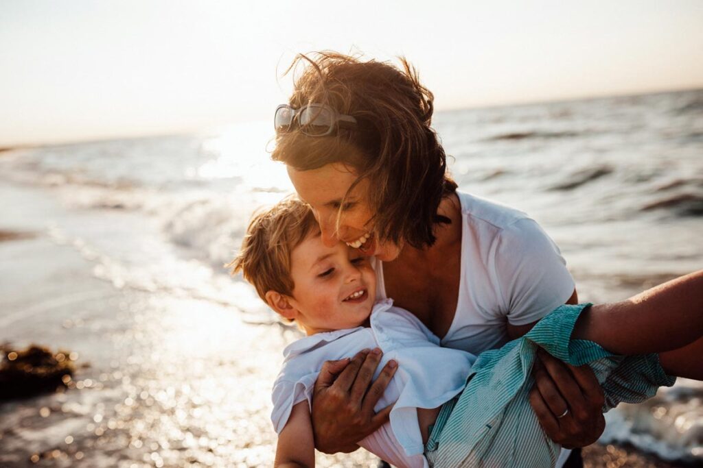 one of the instagram moms laughs with her son on the beach