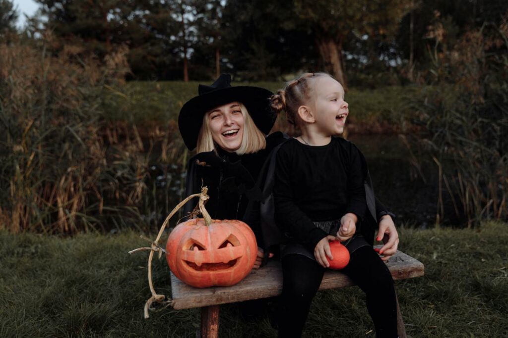 A mother and daughter dressed as witches on their Halloween tradition of tick or treating,