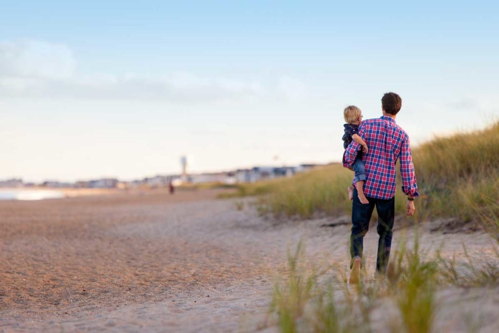 Vater und Kind spazierend am Strand
