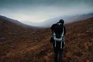 Man with a bag photographing a landscape