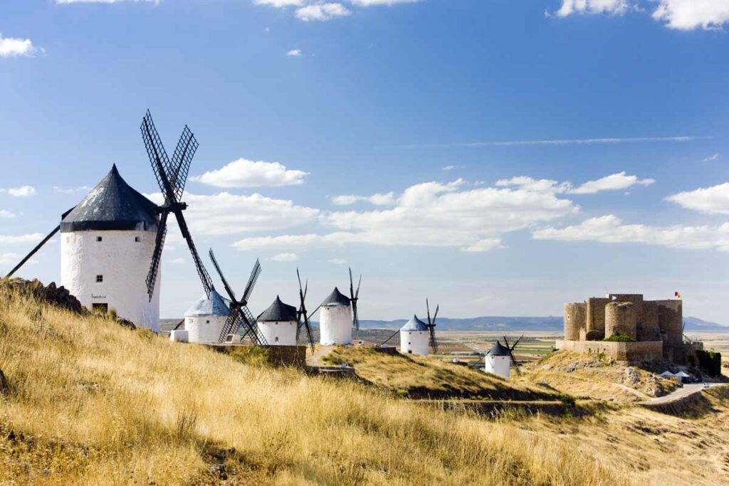 Eine Reihe Windmühle unter blauem Himmel stehen vor einem Schloss