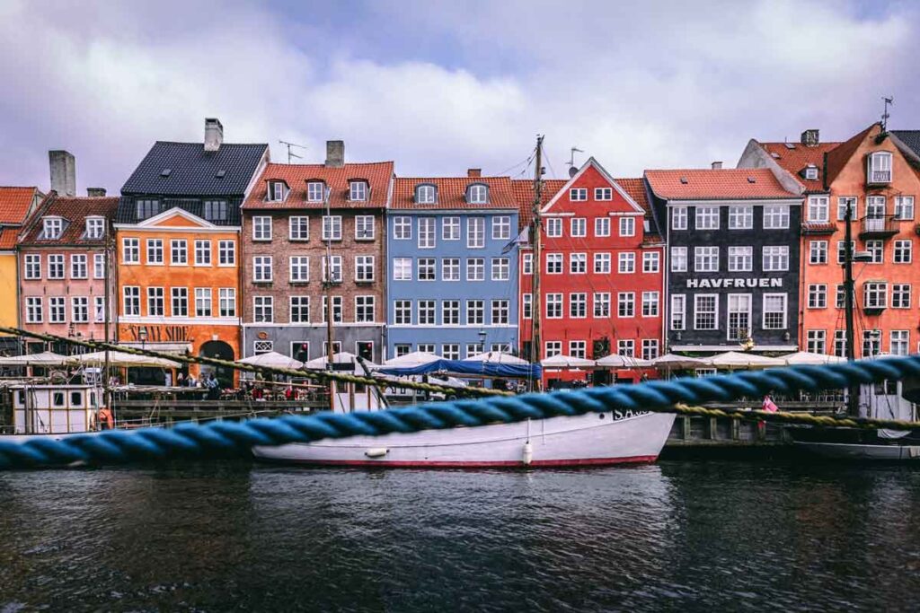 Eine Häuserreihe vor einem Fluss in Dänemark, die als Inspiration für eines die besten Reisebücher gilt