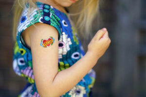 Ein kleines Mädchen hat ein 'Mom' Abzieh Tattoo für Muttertag 2020