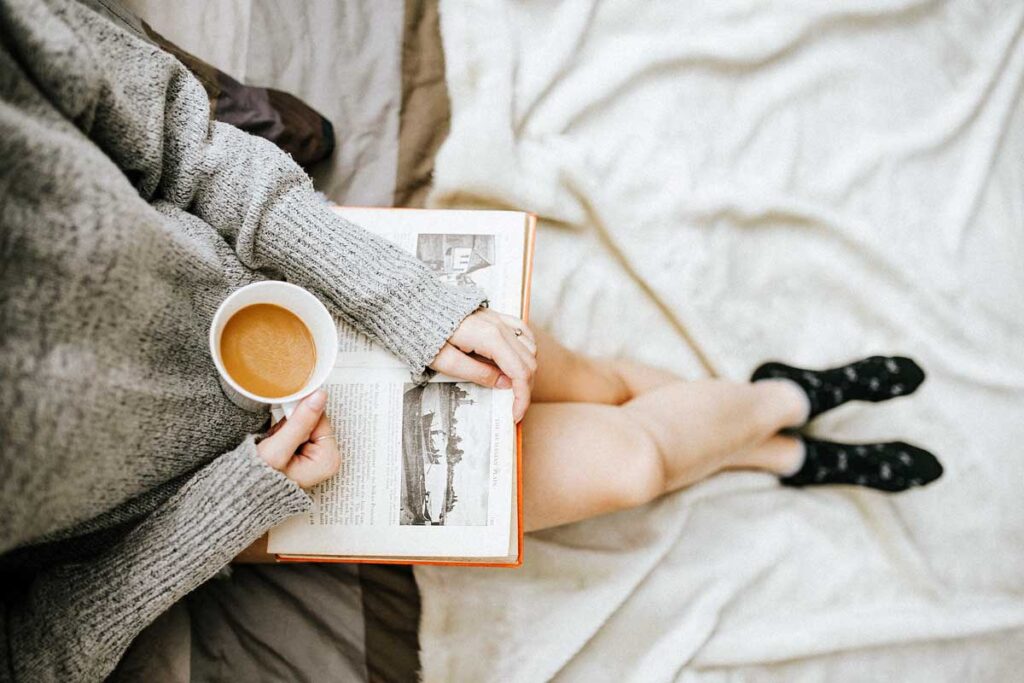 Jemand sitzt mit Kaffee und ein Buch
