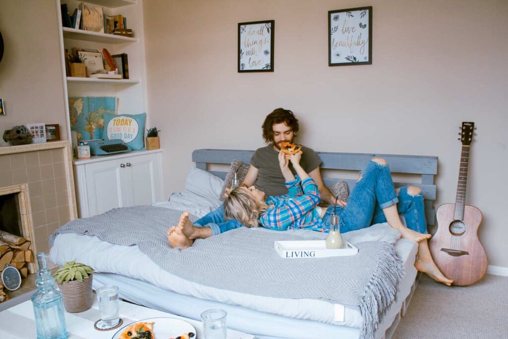 Ein Paar essen im Bett im Urlaub zu Hause