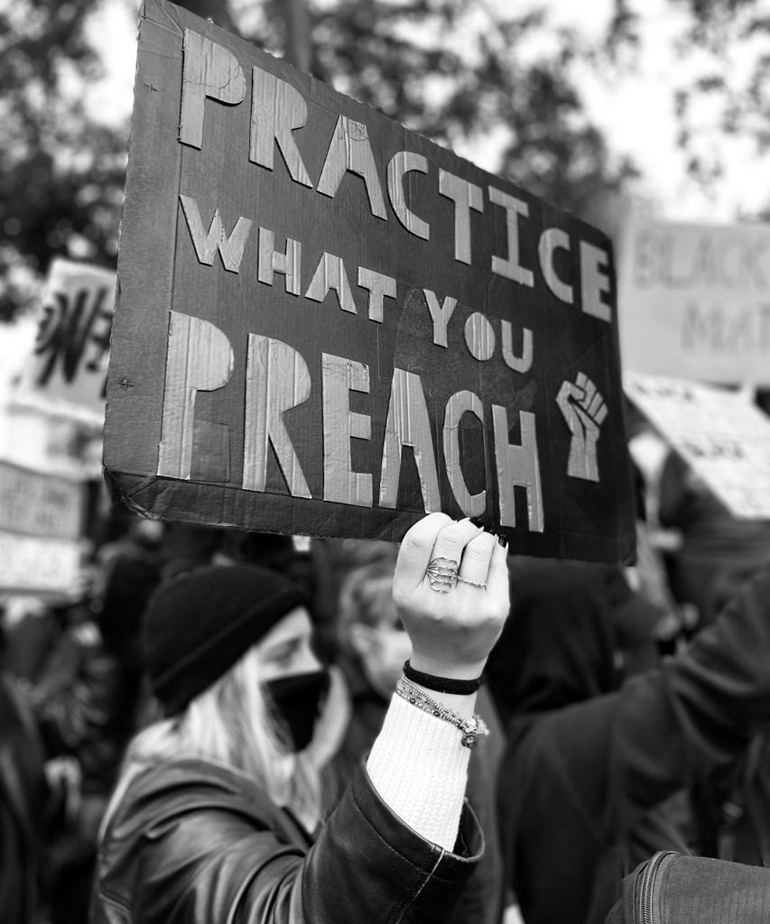 Auf ein BLM Plakat steht 'Tue, was du predigst'