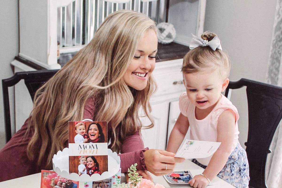mutter zeigt ihrem Kind eine Muttertagskarte 
