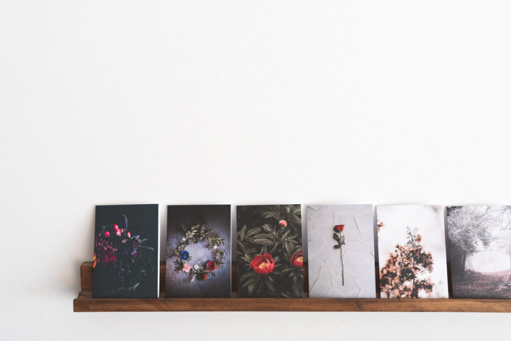 a row of postcards are displayed on a mantlepiece timelessly