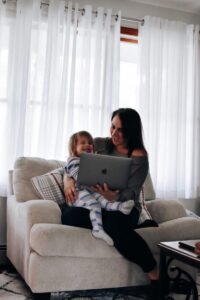 Mother and todler laugh at something on the laptop