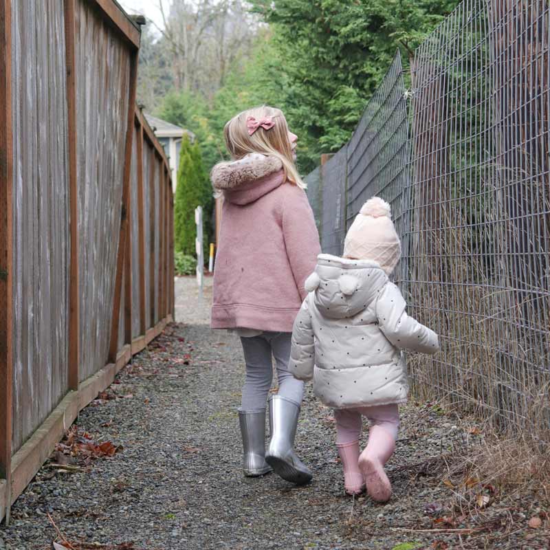 Two little girls search for DIY materials on a walk