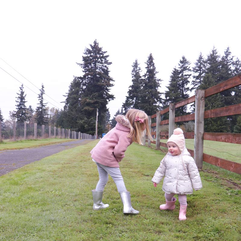 Two kids play on a family walk
