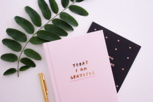 A positive message on a diary next to plants and pens