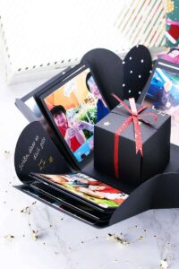 Eine Schachtel innerhalb der Explosionsbox von Fotos umgeben