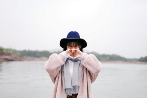 A woman makes a heart with her hands signalling self-love