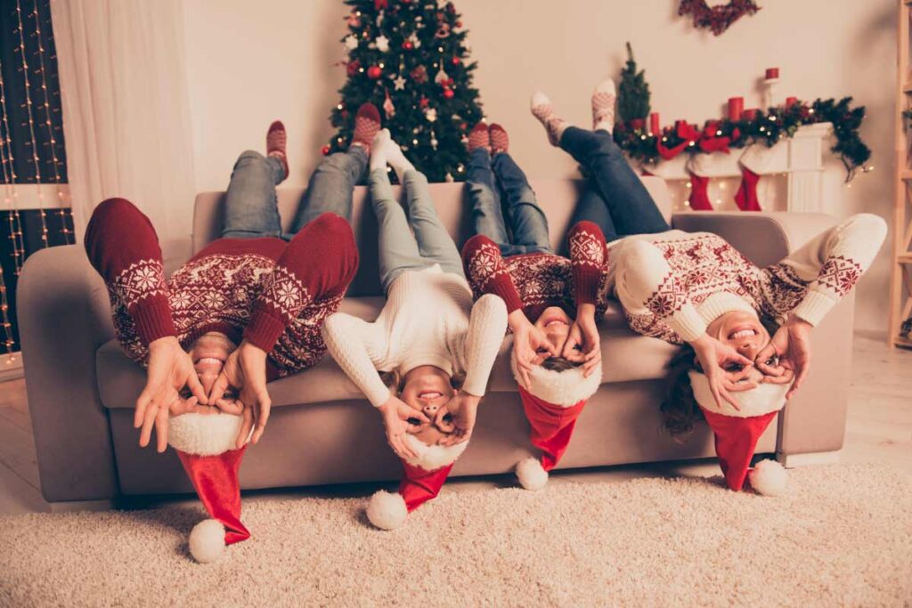 Familie probieren lustige Weihnachtsfoto Ideen aus auf dem Sofa