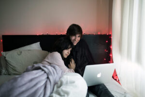 A couple watch an online concert together on their laptop