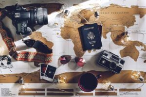 A world map flay lay with passports, photos and more to play your trip