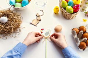 Zwei Hände zeigen Ostern Bastelideen mit Eier und Holz