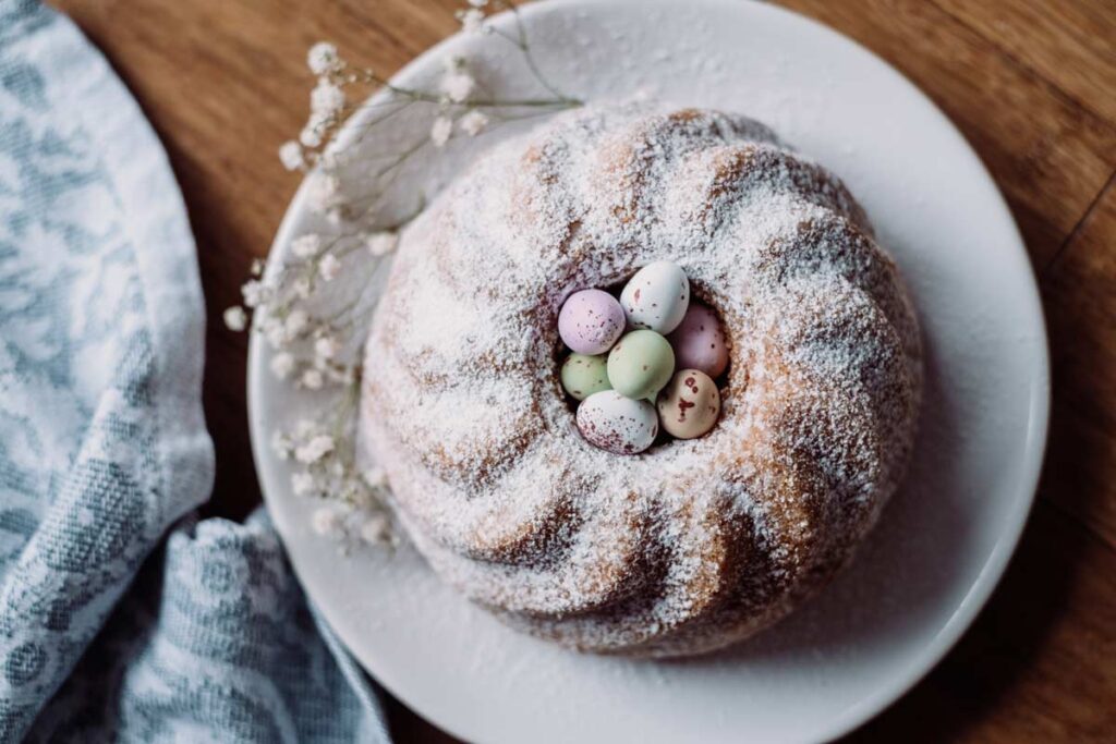 Yummy DIY Easter treats like this sugar powdered cake with mini eggs in the centre