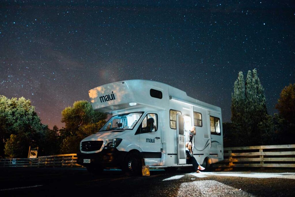 An RV in the nighttime is parked on the road-