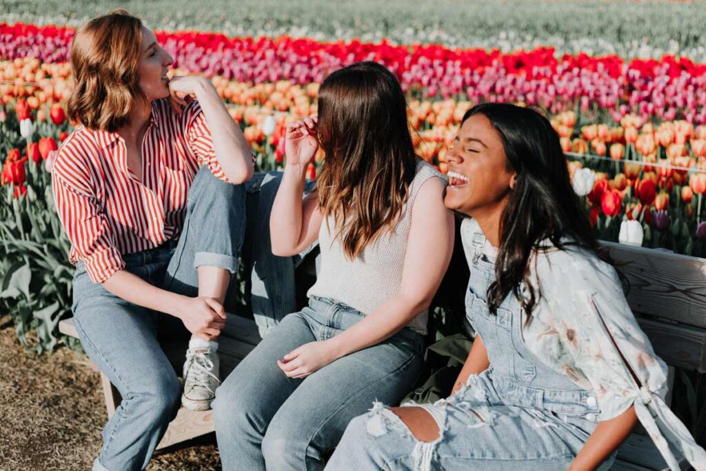 Three young women laughing in a tulip field in a European gap year destination