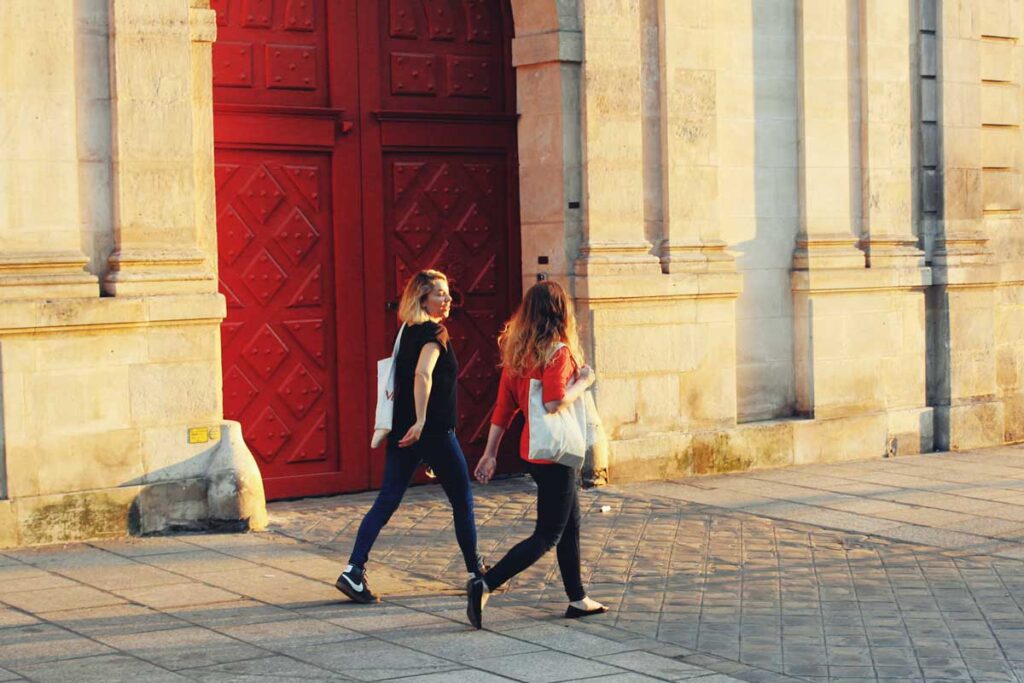 Zwei Frauen laufen entlang eine Straße in Frankreich.