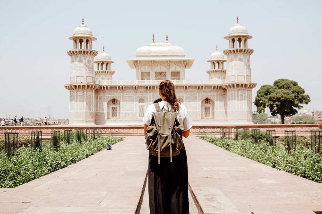 Eine Frau lauft weg zu der Taj Mahal