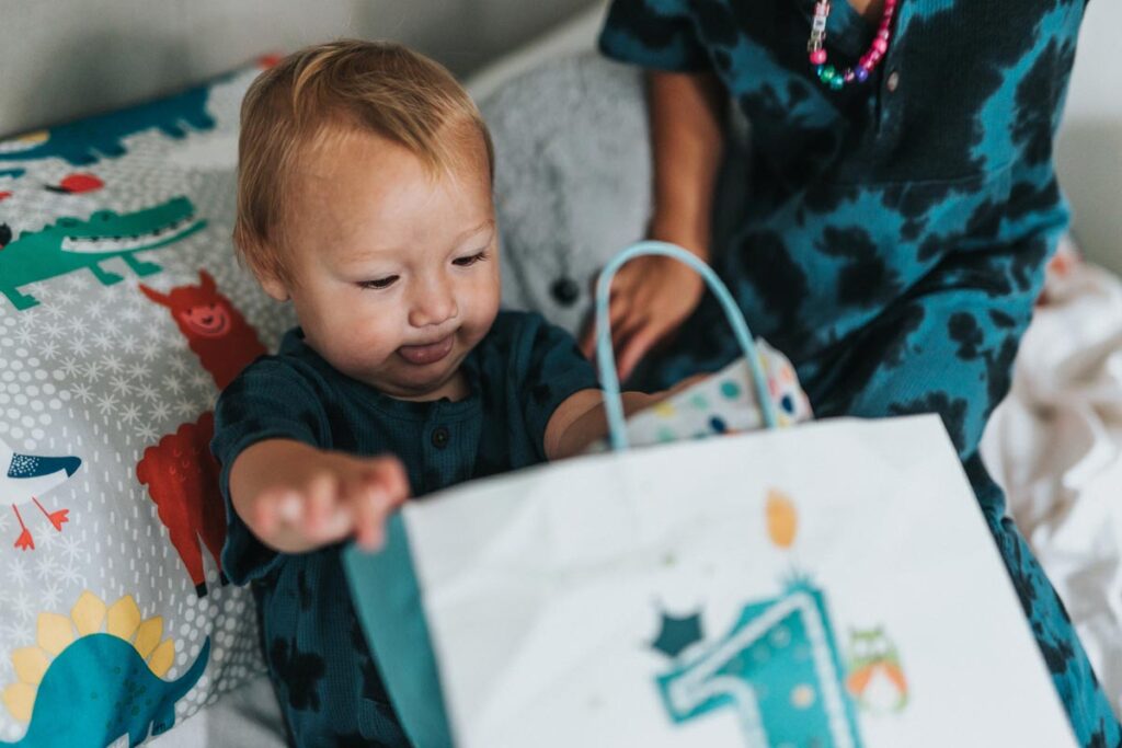 Ein Baby am seinem 1. Geburtstag guckt in einem Tasche mit der Nummer 1 darauf.