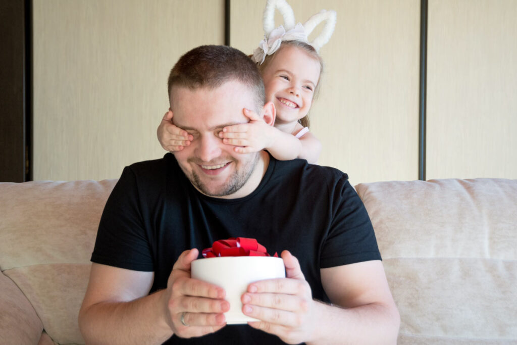 Ein kleines Mädchen überrascht seinen Papa am Vatertag mit einem Geschenk