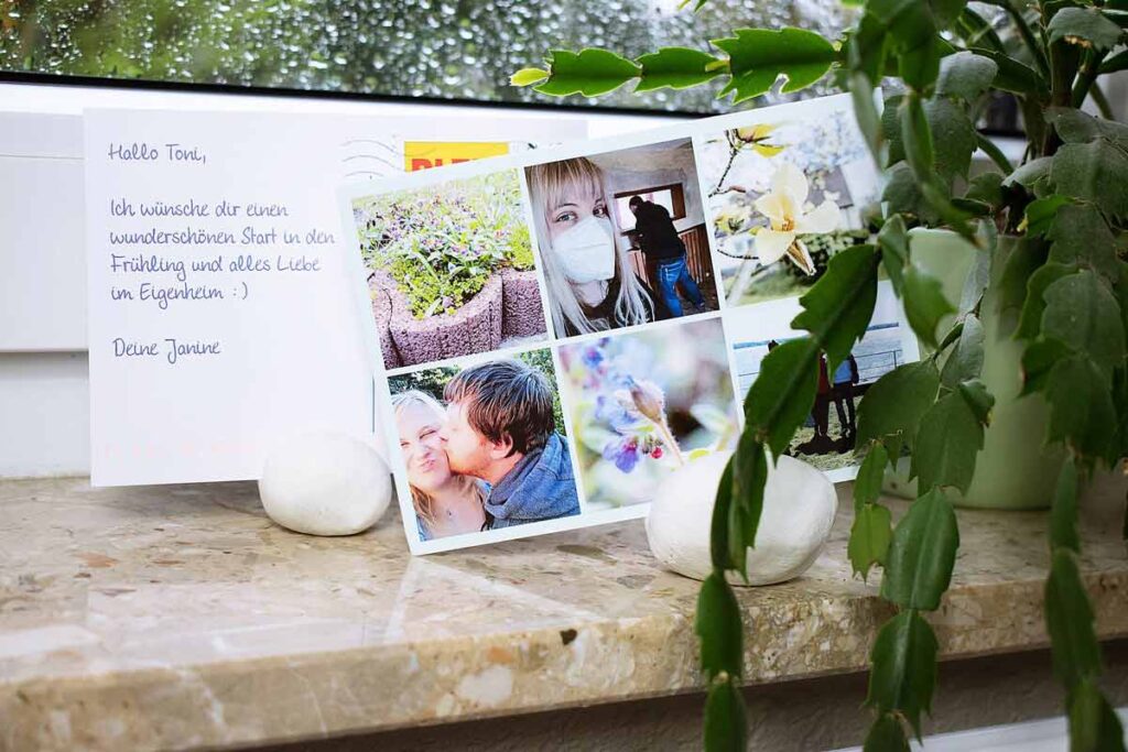 Eine Postkarte mit 6 Fotos drauf sitz in den DIY Postkartebehalter. Im Vordergrund steht eine Pflanze.