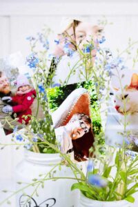 2 DIY upcycled Vasen nah gesehen mit fokus auf Blumen und Fotos drin.