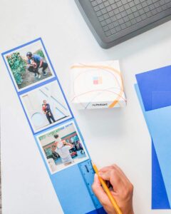A hand sticking on the photos - three prints are already stuck on.