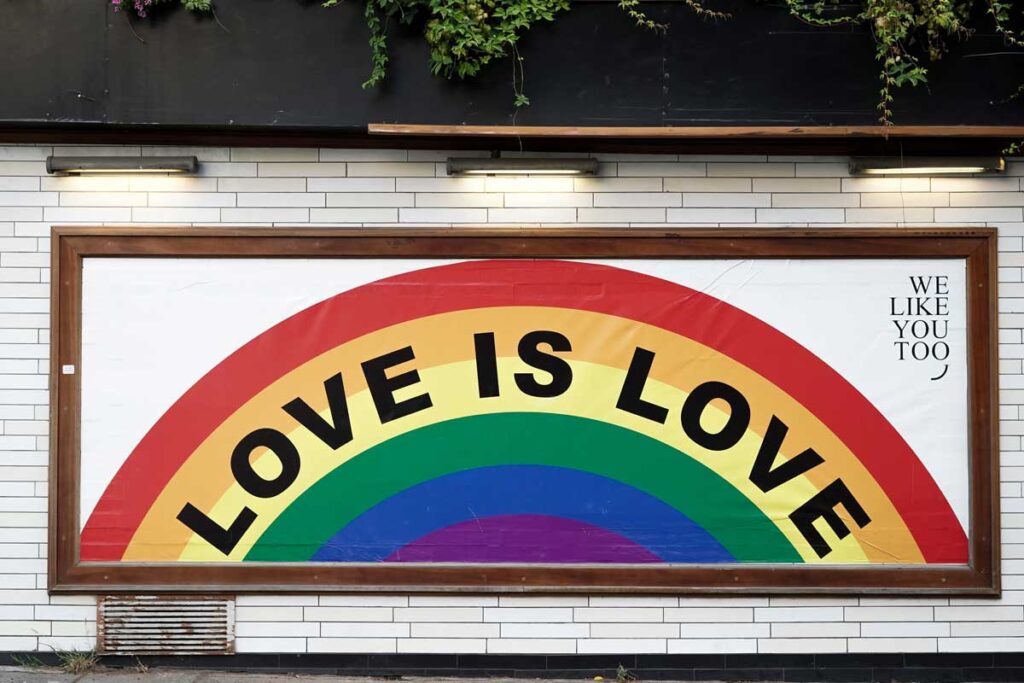 Pride Srüche auf einen Wand. Text innerhalb einen Regenbogen.