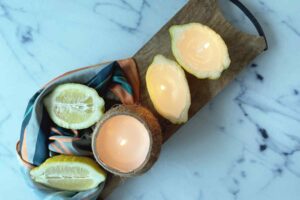 The finished DIY candles lie on a wooden board lit-