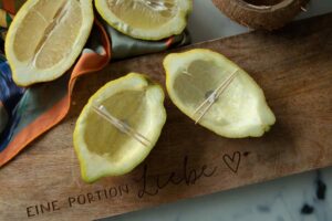 4 lemon shells on the wooden board, in two of them a wick held in place by tooth picks in the empty lemon halves.