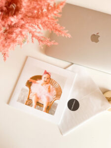 Photobook by MyPostcard next to a macbook with a hand touching the photos