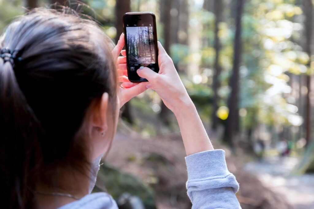 A woman taking a photo on one of our best hiking apps