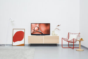 A top interior blogger's living room with TV, sideboard, painting and chair.
