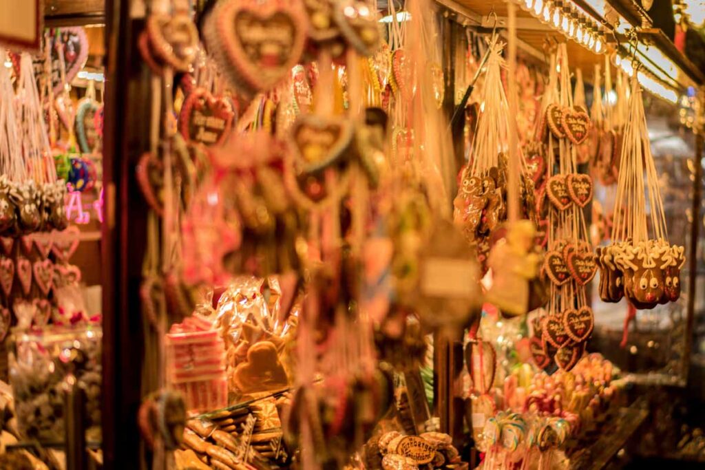 Lebkuchen hearts hanging from a festive booth at a winter market.
