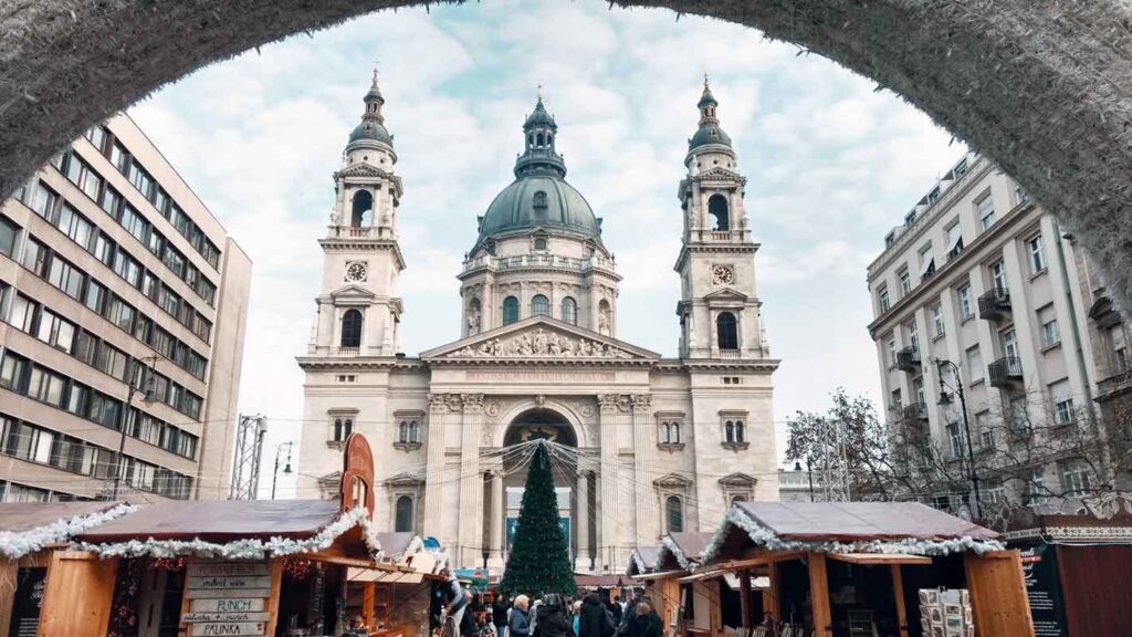 The Budapest based best Christmas market in Europe seen through a tunnel facing the church