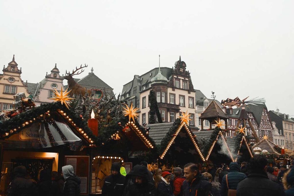 A line of Christmas market stalls in front of traditional German buildings in one of the best markets in Europe, Trier.