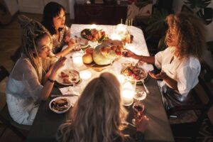 A group of friends sit around hosting a Friendsgiving with our tips