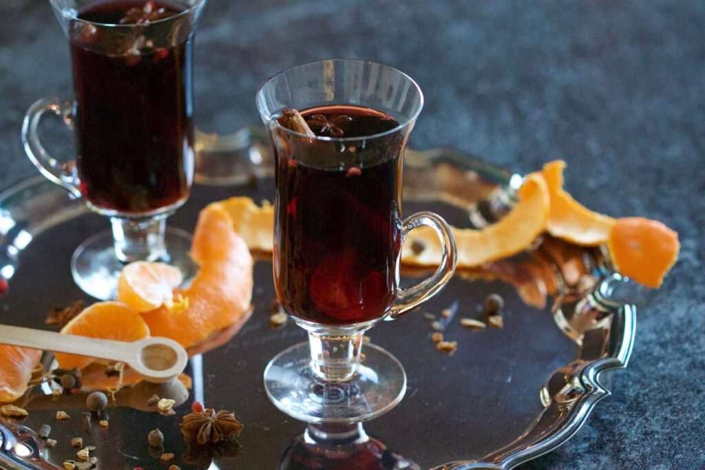 mulled wine in glasses on a tree next to orange peel