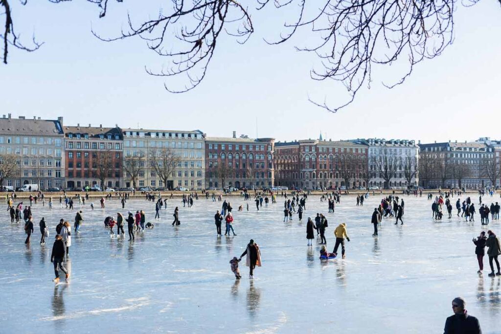People skating on a frozen lake in the city
