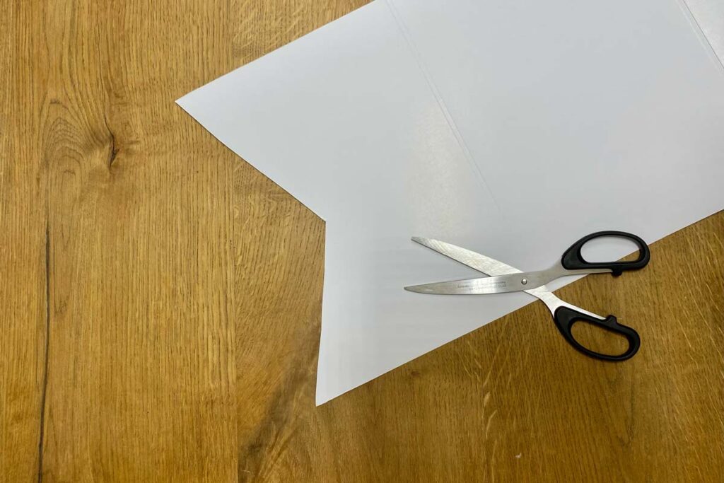 Scissors lying on top of a white banner which has been cut into a ribbon end.