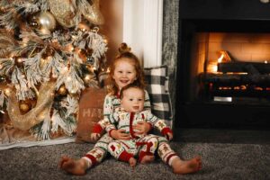 A New Year photo shoot involving two siblings - a baby sitting in the arms of his sister