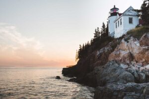 A sunset picture of a house on the coast of Maine