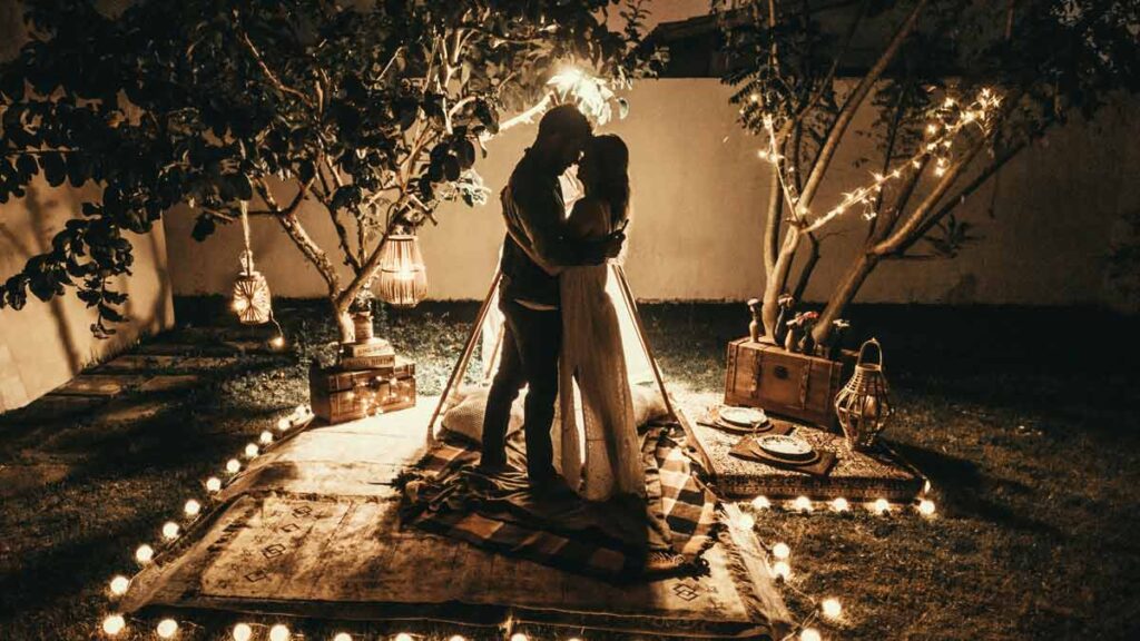 A couple posing in the light of candles for pre-wedding photo shoot ideas